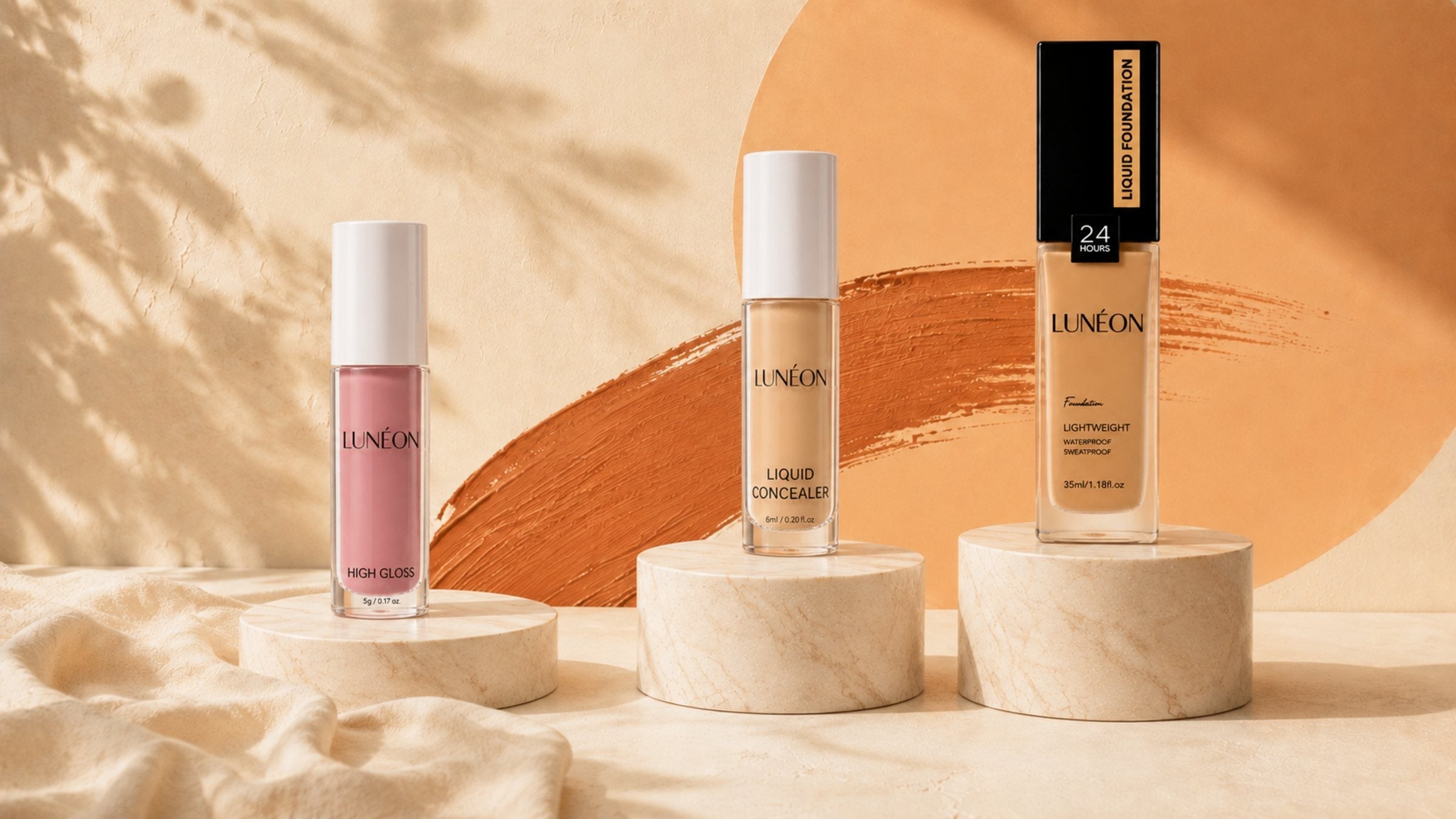 LUNÉON High Shine Lipgloss, Liquid Concealer und Liquid Foundation auf drei Marmorpodesten
